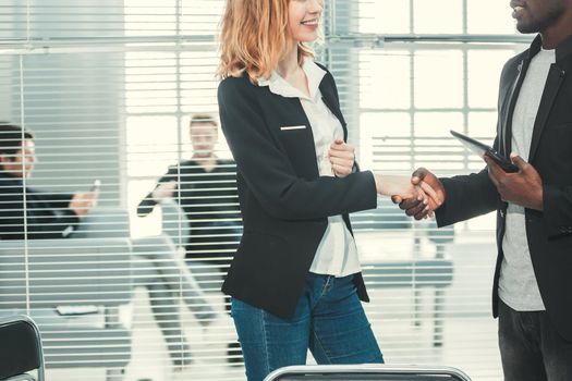 close up. young business colleagues shaking hands with each other.