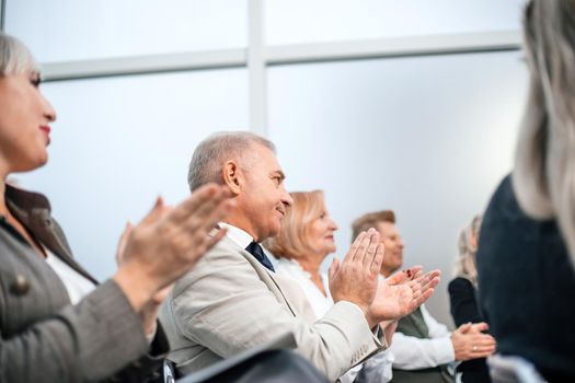 close up. a group of business people applaud during a business seminar. business and education