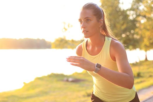 Young woman in sports clothing running while exercising outdoors