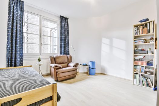 Cozy single bedroom with a comfortable brown armchair