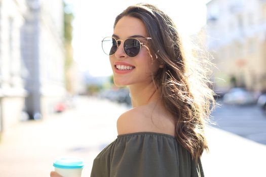 Smiling happy young beautiful woman walking outdoors