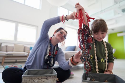 Mother and little girl daughter playing with jewelry while staying at home in coronavirus quarantine