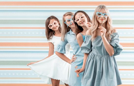 Smiling teenage girls posing emotionally on striped background