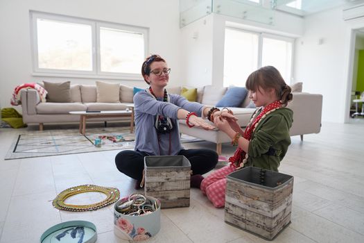 Mother and little girl daughter playing with jewelry while staying at home in coronavirus quarantine