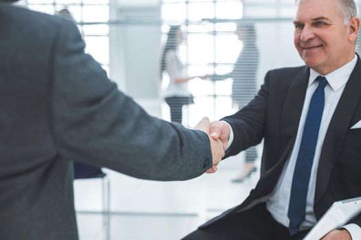 close up. handshake of business partners in the background of the office. concept of cooperation