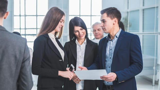 group of young employees standing in the office lobby during a work break. office workdays