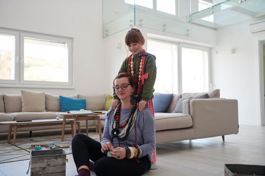 Mother and little girl daughter playing with jewelry while staying at home in coronavirus quarantine