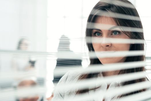 close up. young business woman looking through office window