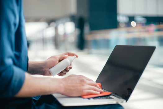 close up. man wiping dust from the laptop keyboard . concept of health protection