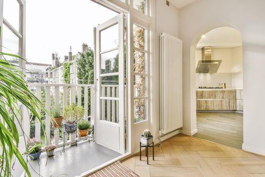 Open door leading to a balcony with many flowers