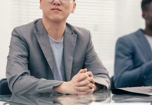 close up. young businessman sitting at the negotiating table. business people