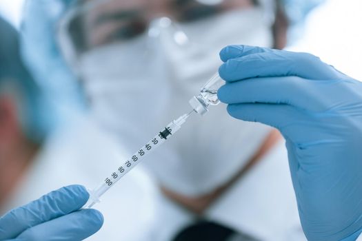 close up. scientist filling a syringe with a new vaccine. vaccination concept.