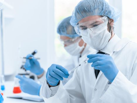 close up. group of scientists in protective clothing working in the laboratory. photo with a copy-space.