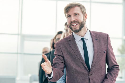 close up. smiling businessman holding out his hand for a handshake. business people