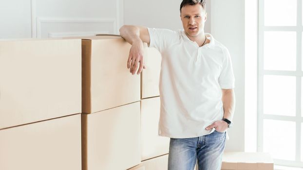 confident young man standing in his new apartment. photo with copy-space