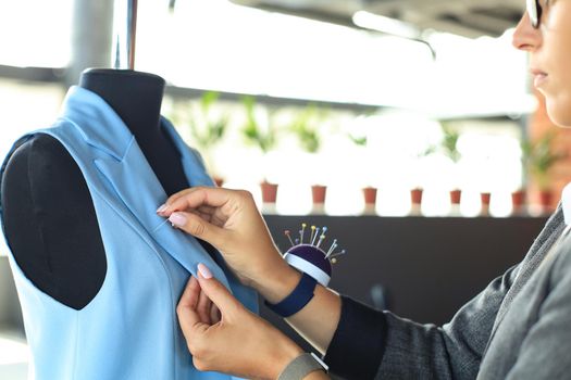 Young fashion designer working in her atelier on new cloths