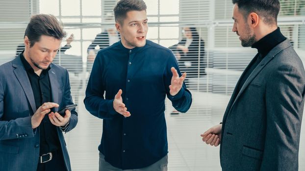 group of employees talking standing in the office. business concept.