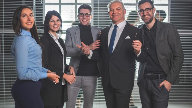 boss and happy business team standing in office lobby. the concept of successful work