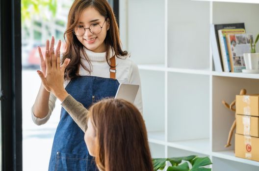 Sell products to business owners online. Focus on the face of a woman in white expressing joy to a friend whose online sales exceeded their expectations