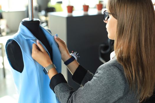 Young fashion designer working in her atelier on new cloths