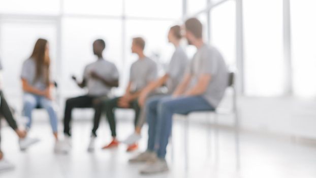 background image of a group of young people at a meeting in a conference room. photo with copy space