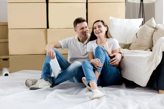 happy couple sitting near boxes in a new apartment. photo with copy-space