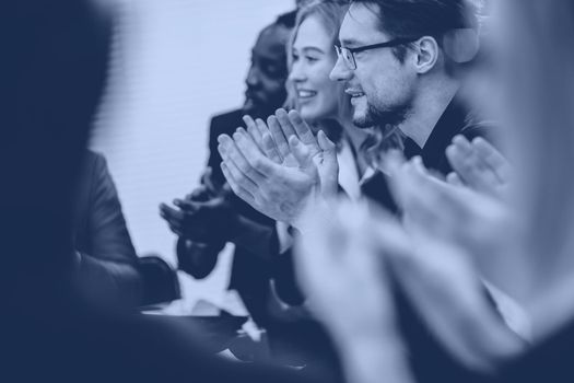 close up.a multinational group of young business people applauding at the meeting. success concept