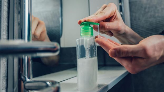 close up. man pressing the dispenser with bactericidal soap. concept of prevention of infectious diseases.