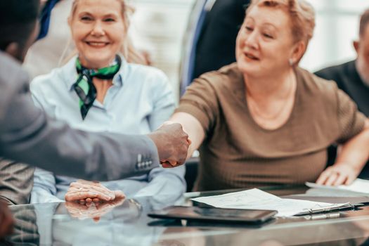 close up. senior businesswoman shaking hands with a young business partner. business concept