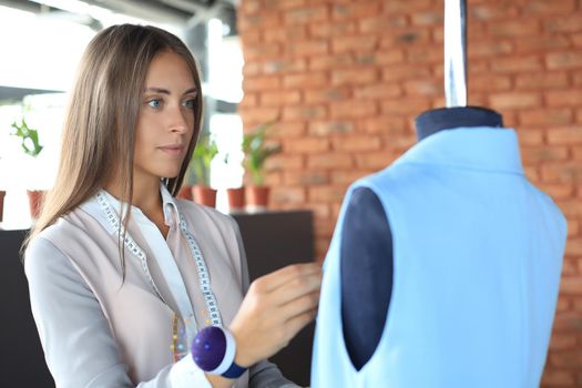 Young fashion designer working in her atelier on new cloths