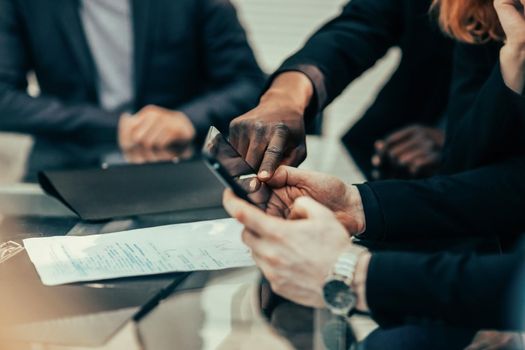 close up. business colleagues viewing messages on a smartphone. people and technology