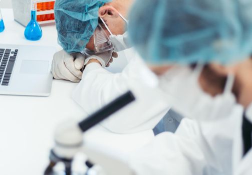 close up. tired scientist sleeps on his Desk in the laboratory. photo with a copy-space.