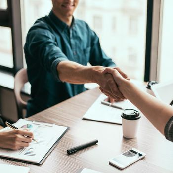 close up. young business people shaking hands with each other. business concept.