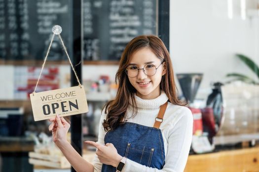 Startup stores, small business owners Standing to display a sign at the reception for customers who will come to use the service in the shop after the coronavirus situation began to unfold