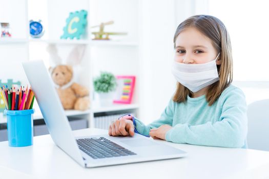 Cute little girl studying at home during quarantine