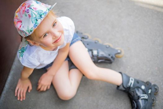 Beautiful little girl on roller skates in park, top view