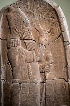 Babylonian bas relief in Berlin Pergamon museum in Germany. Historical ancient art of east religion and civilization made on stone wall. Antique islamic decoration with man