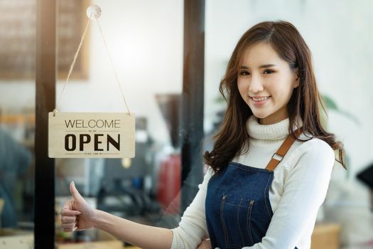 Startup stores, small business owners Standing to display a sign at the reception for customers who will come to use the service in the shop after the coronavirus situation began to unfold