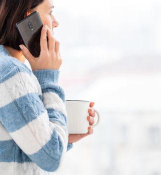 Girl talking on phone while drinking from cup