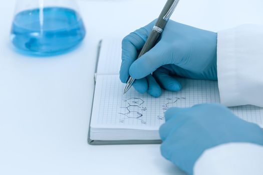 close up. scientist virologist recording test results in a journal. photo with a copy-space.