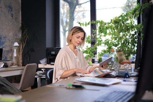 Beautiful business woman on the workplace using a digital tablet.