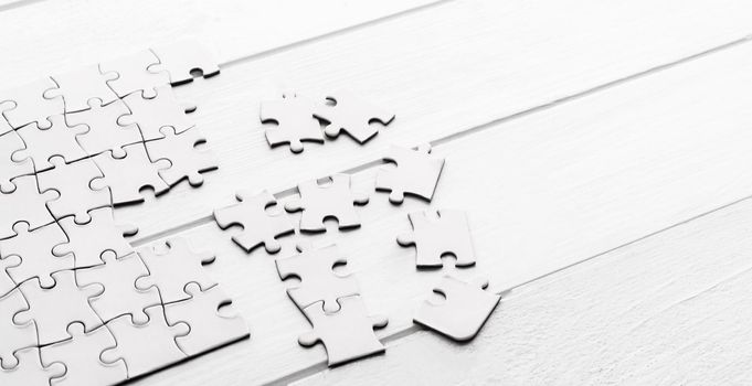 Pieces of empty jigsaw puzzle on white table