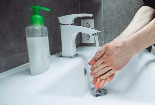 close up. man carefully washes his hands under the tap.