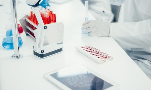 digital tablet and ampoules with the vaccine on the table in the laboratory. photo with a copy of the space.