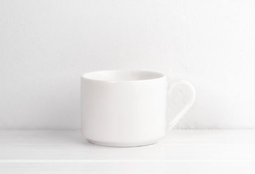 Ceramic cup on white table for your design