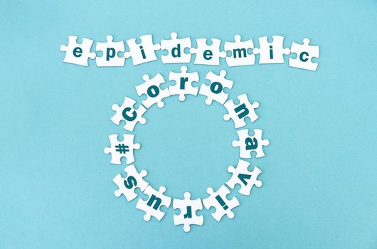Circle and row made of white jigsaw puzzle pieces with word epidemic andcoronavirus on blue