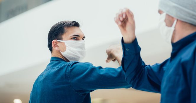 close up. young man in a protective mask while welcoming his friend