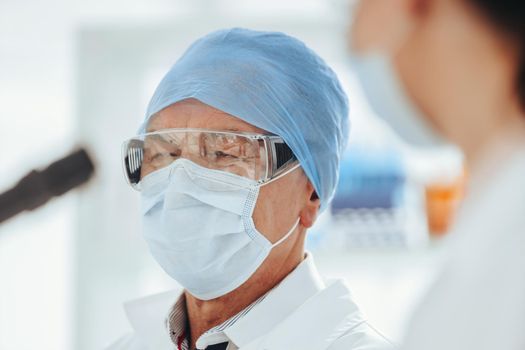 close up. female scientist looking through a microscope . science and public health.