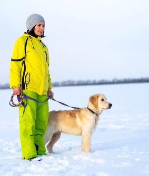 Happy woman with beautiful dog walking in winter