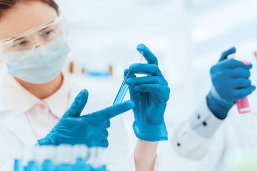 close up. female scientist looking at the liquid in the test tube. science and health.
